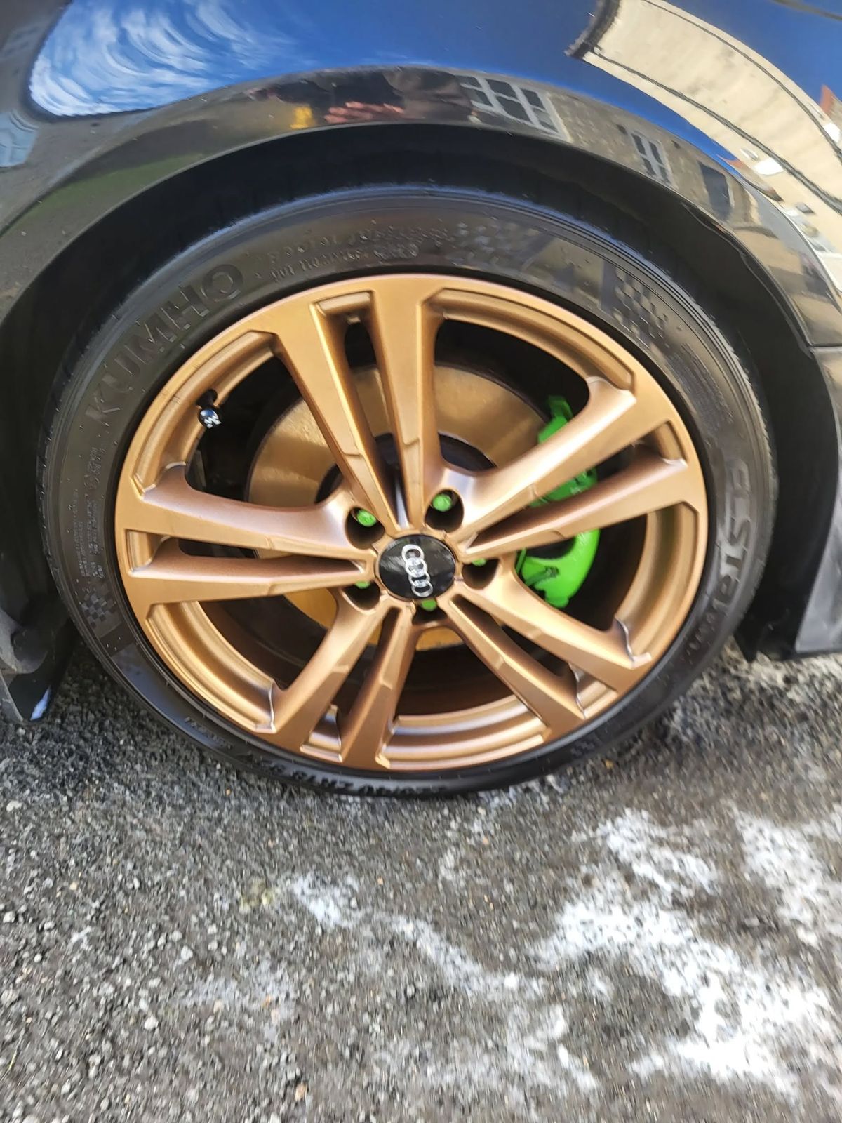 The same bronze alloy wheel after valeting, bright metallic finish and a deep black tyre